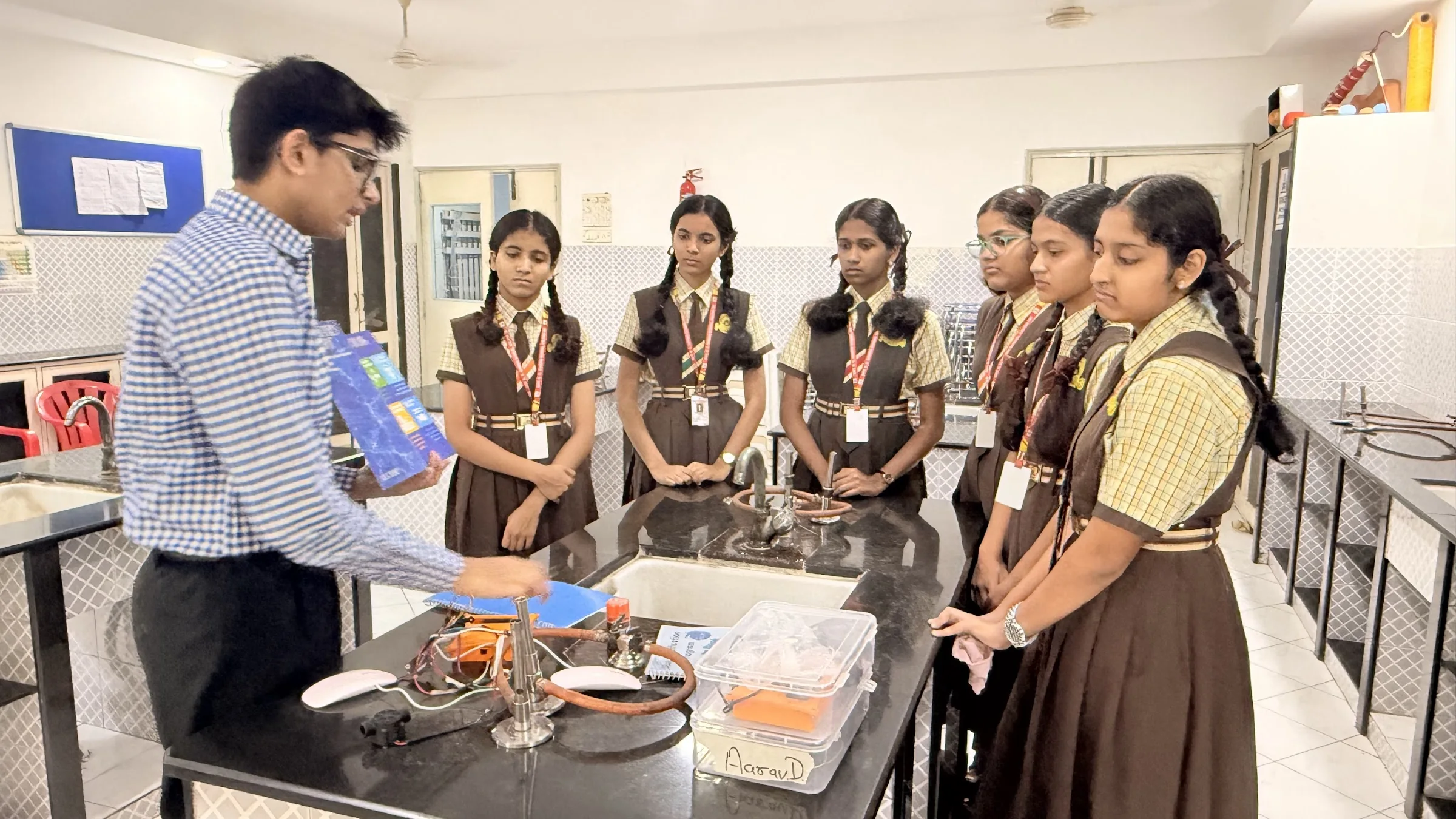 Students receiving hands-on guidance during a school science demonstration