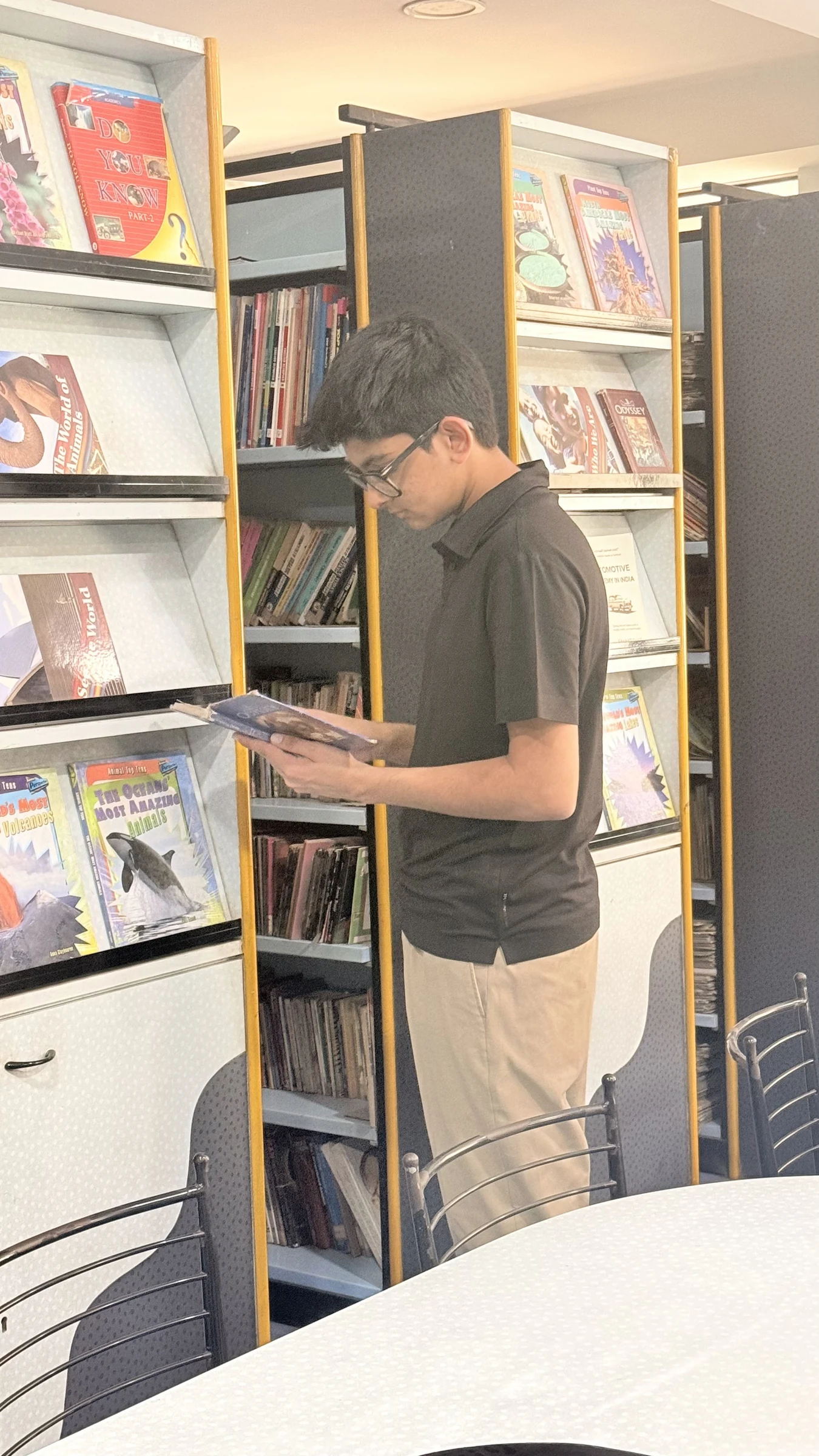 Aarav pointing out books in the school library