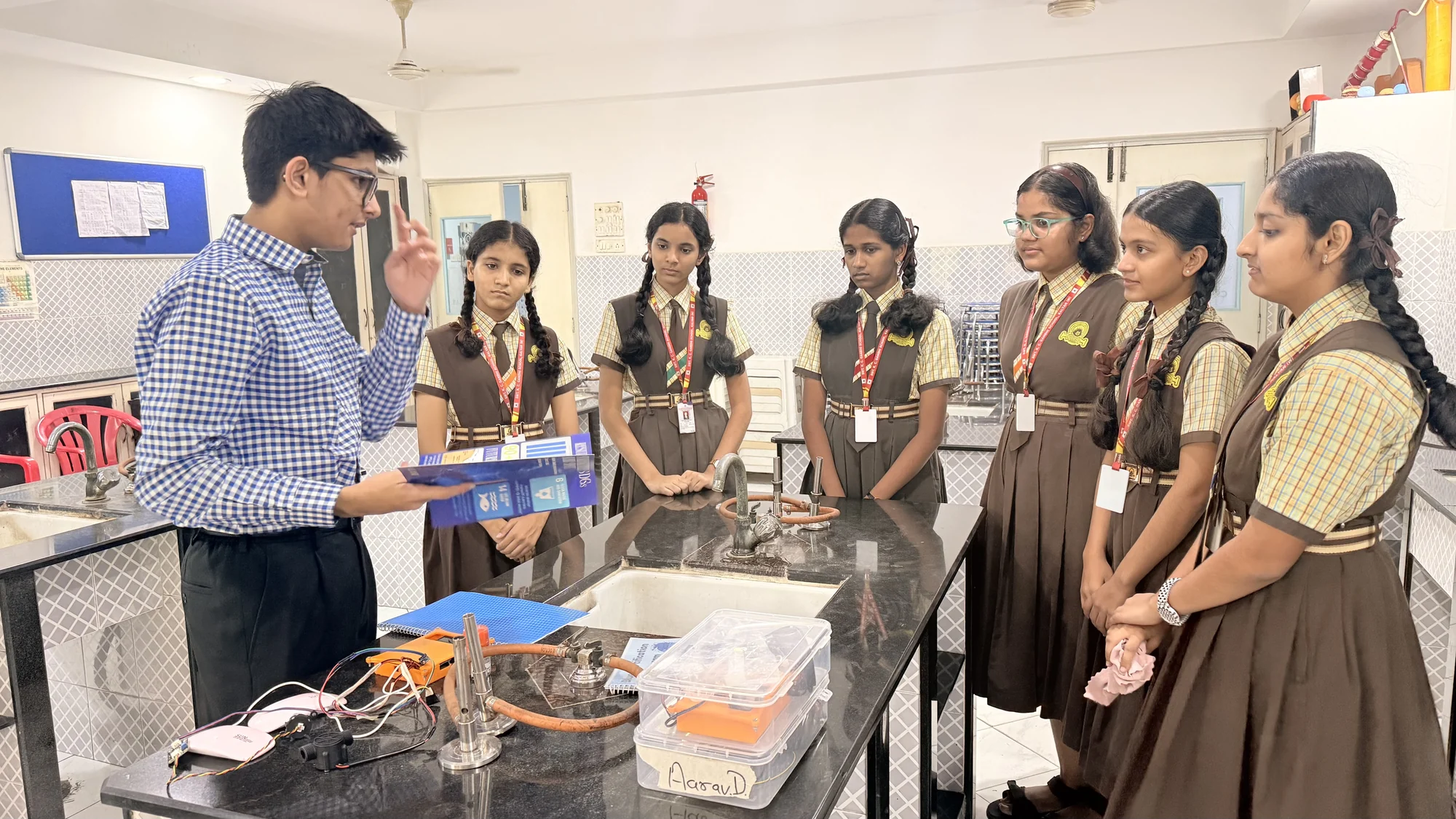 Students gathered around a laboratory bench for a practical science demonstration