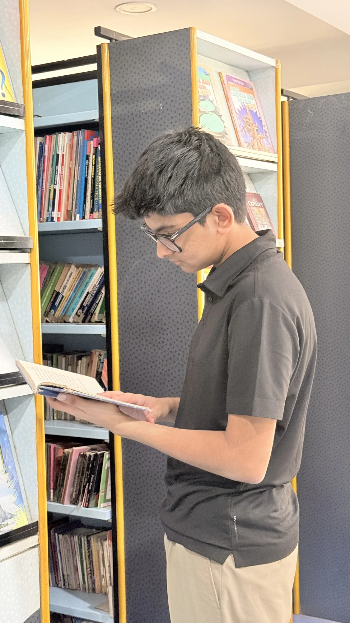 Aarav reading from learning material at the school