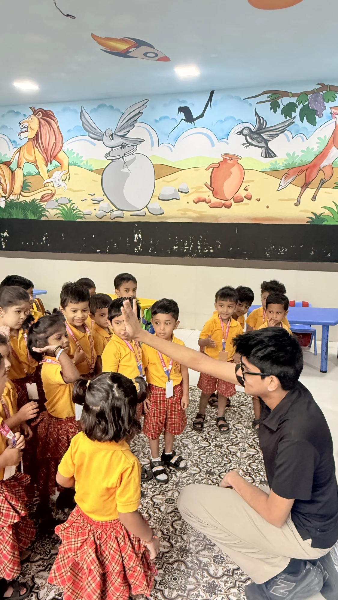 A facilitator and younger students discussing science in a classroom