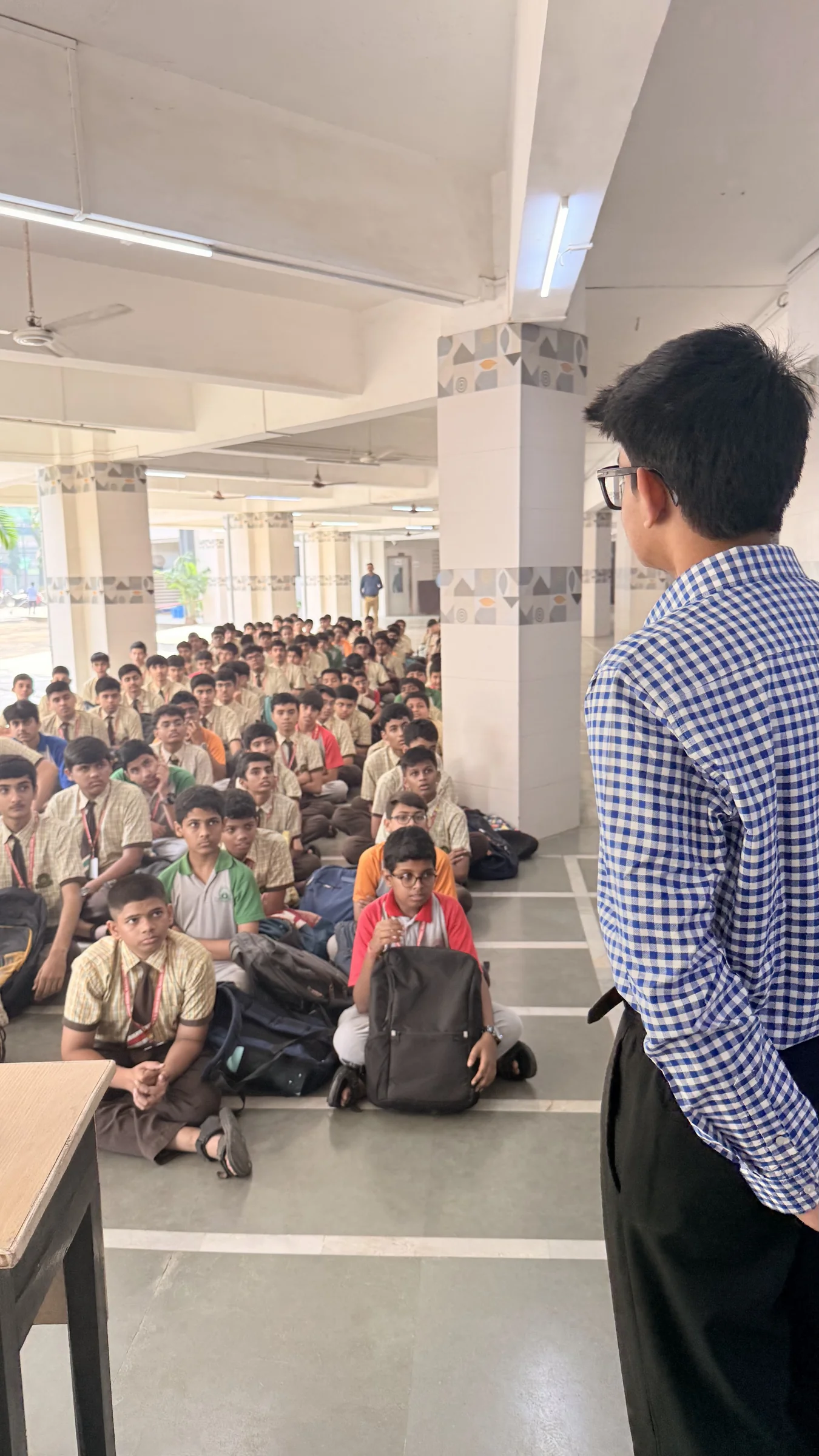 Aarav speaking with students in the school hall